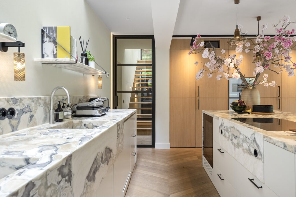 Modern kitchen with marble countertops and wood accents.
