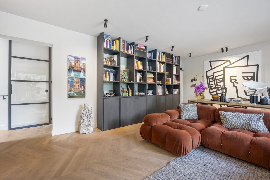 Modern living room with bookshelf and art.