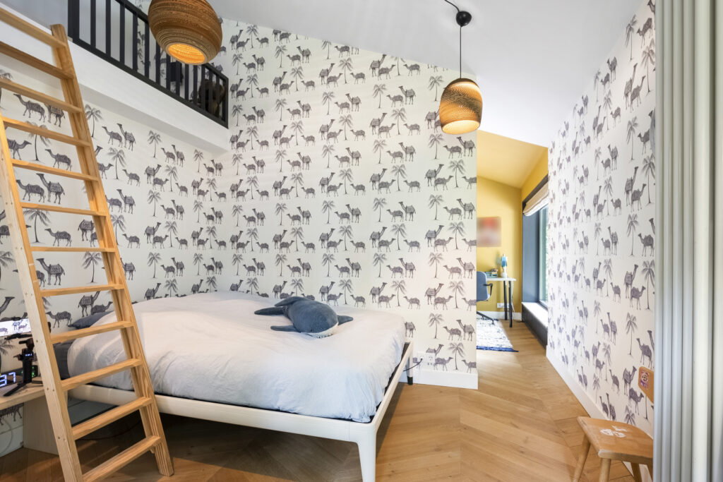 Bedroom with animal wallpaper and loft bed ladder.