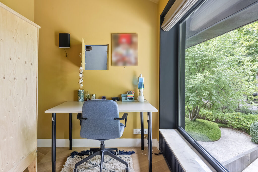 Home office with yellow walls and large window