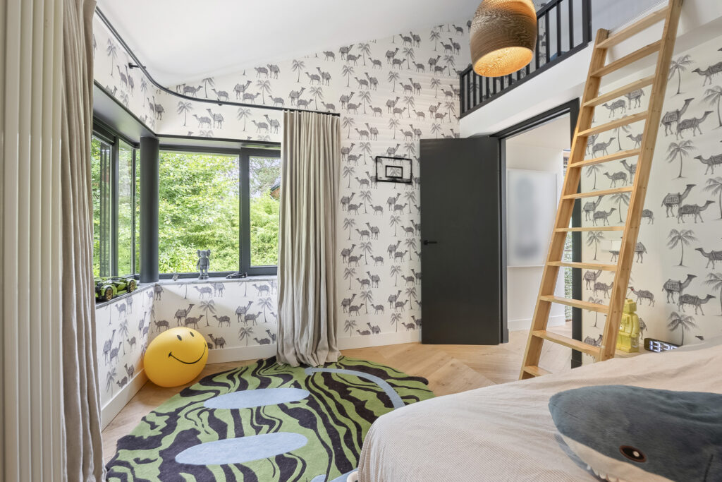 Children's room with cheerful decor and animal wallpaper.