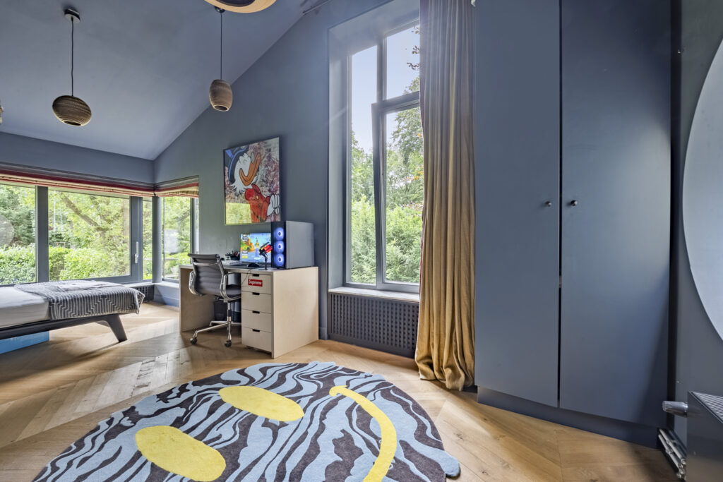 Modern bedroom with desk and colorful rug.