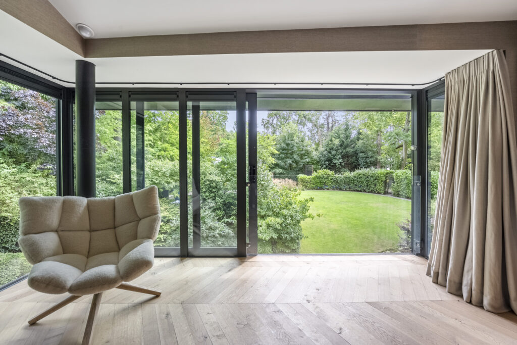 Modern room with large windows and garden view.