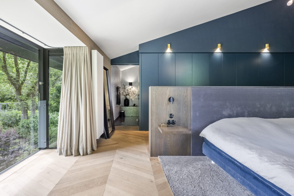 Modern bedroom with large window and elegant decor.