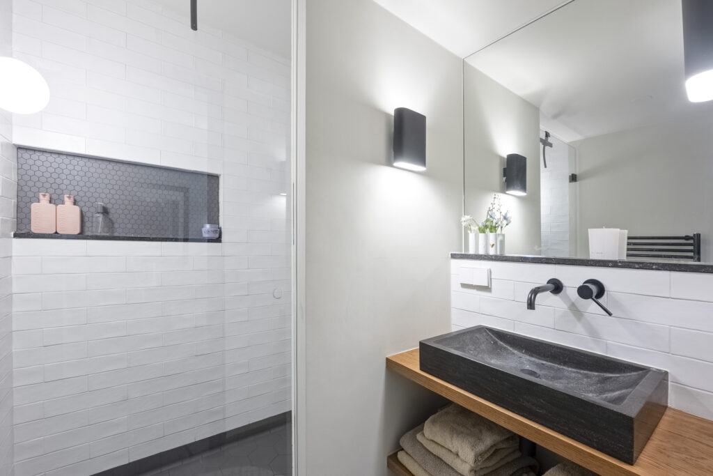 Modern bathroom with stone sink and tiled shower