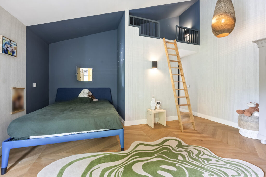 Child's bedroom with loft, ladder, and toys.