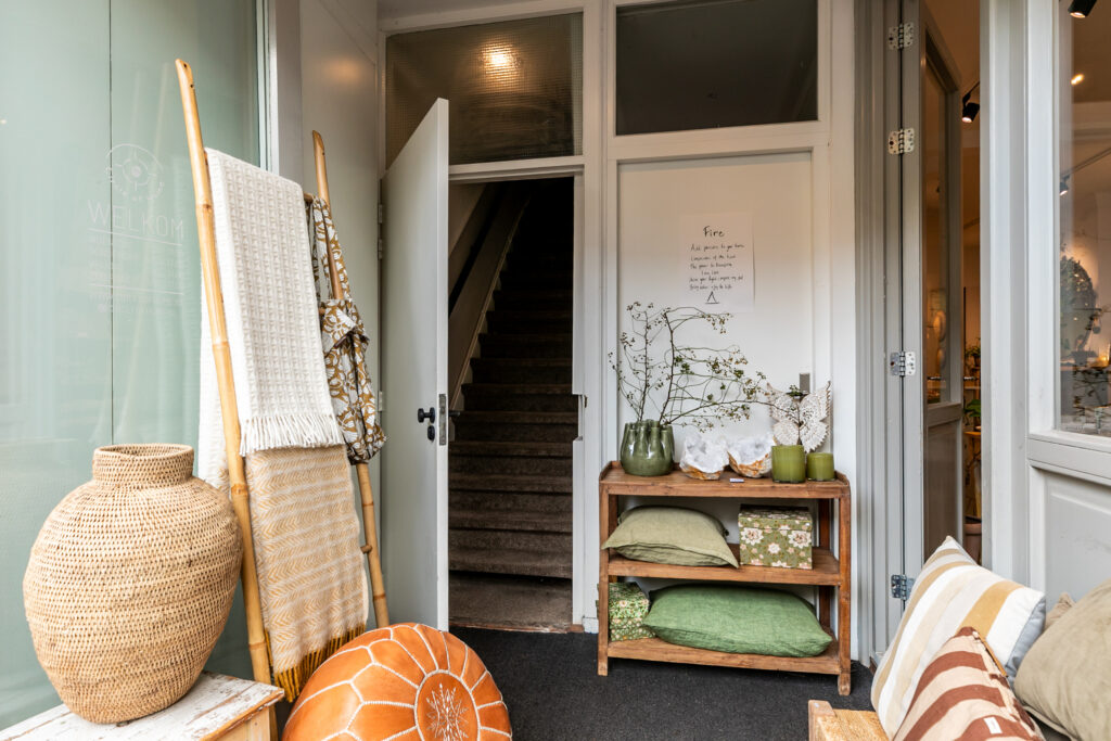 Cozy entrance with cushions, plants, and decor.