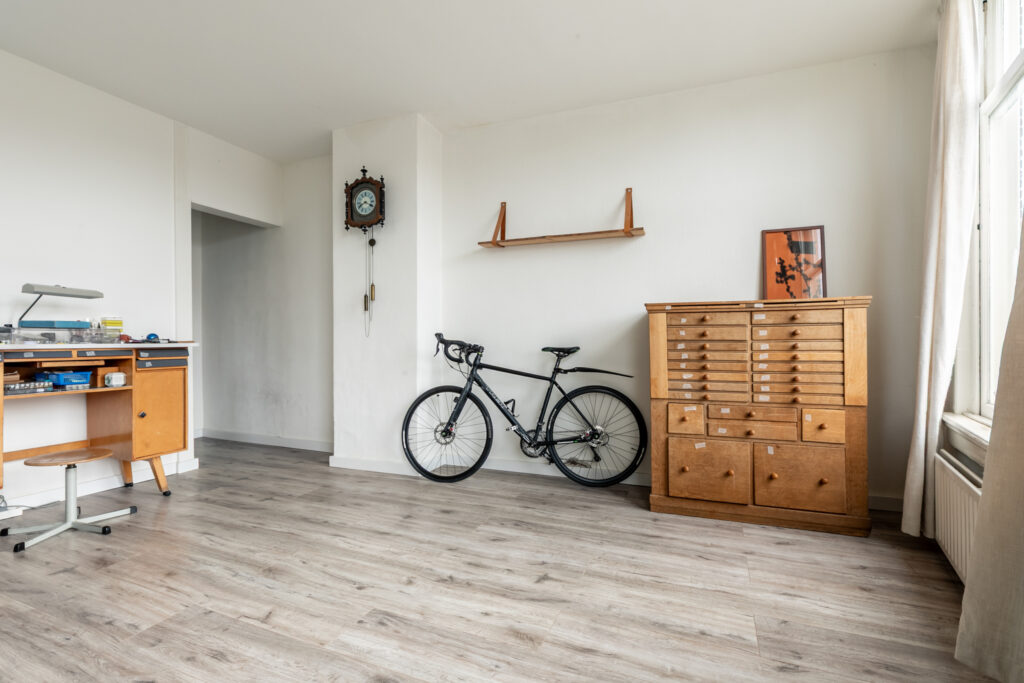 Minimalist room with bicycle, desk, cabinet.