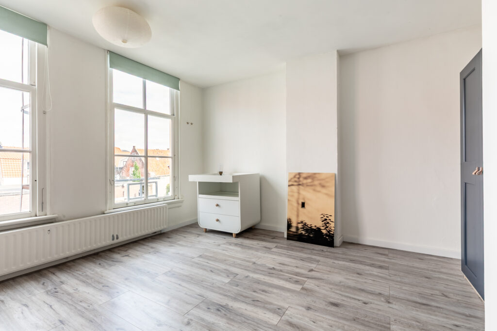 Minimalist room with large windows and wooden floor.