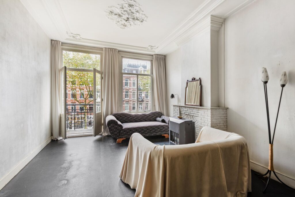 Spacious living room with sofas and open balcony.