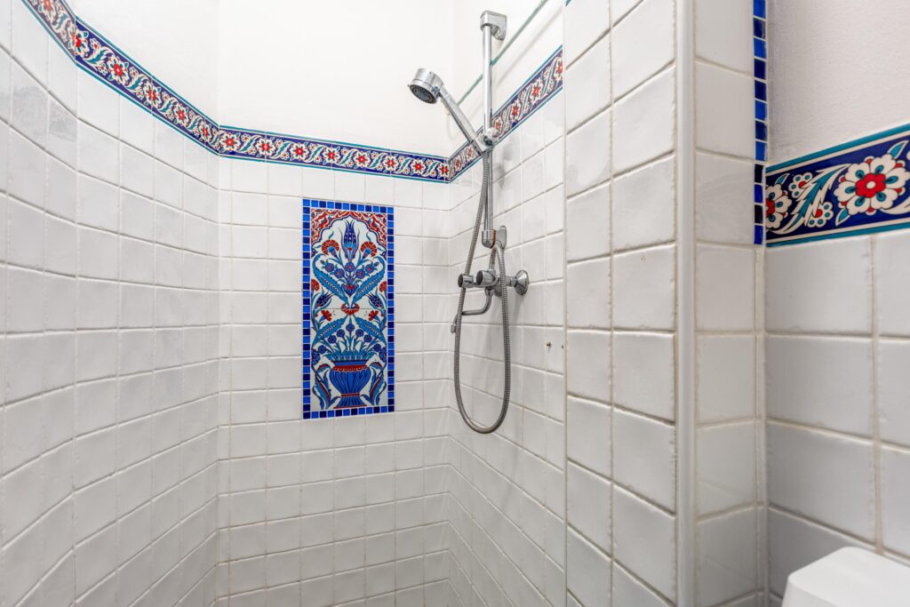 Decorative tiled shower with intricate floral patterns.