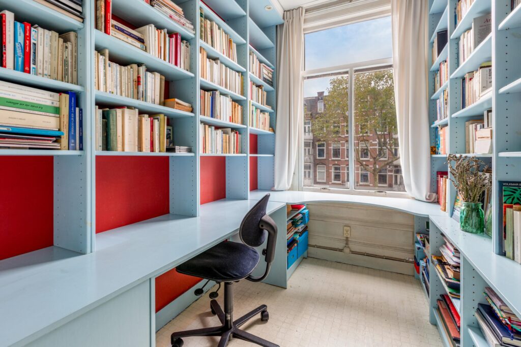 Cozy study room with bookshelves and window view.