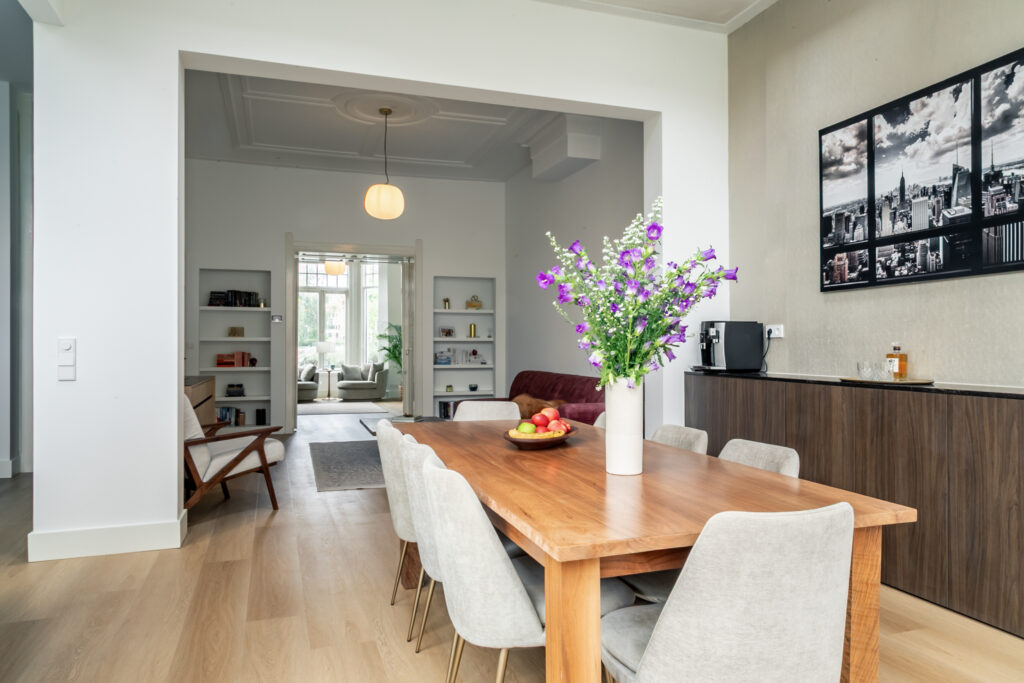 Modern dining room with flowers and wooden table.