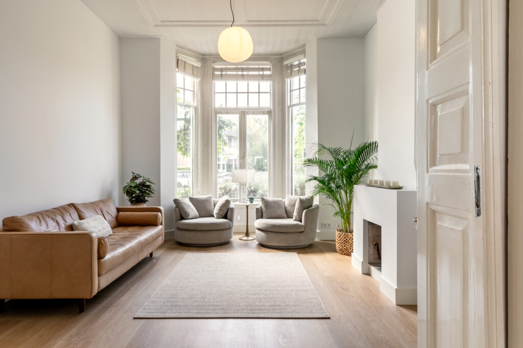 Bright living room with modern furniture, large windows.