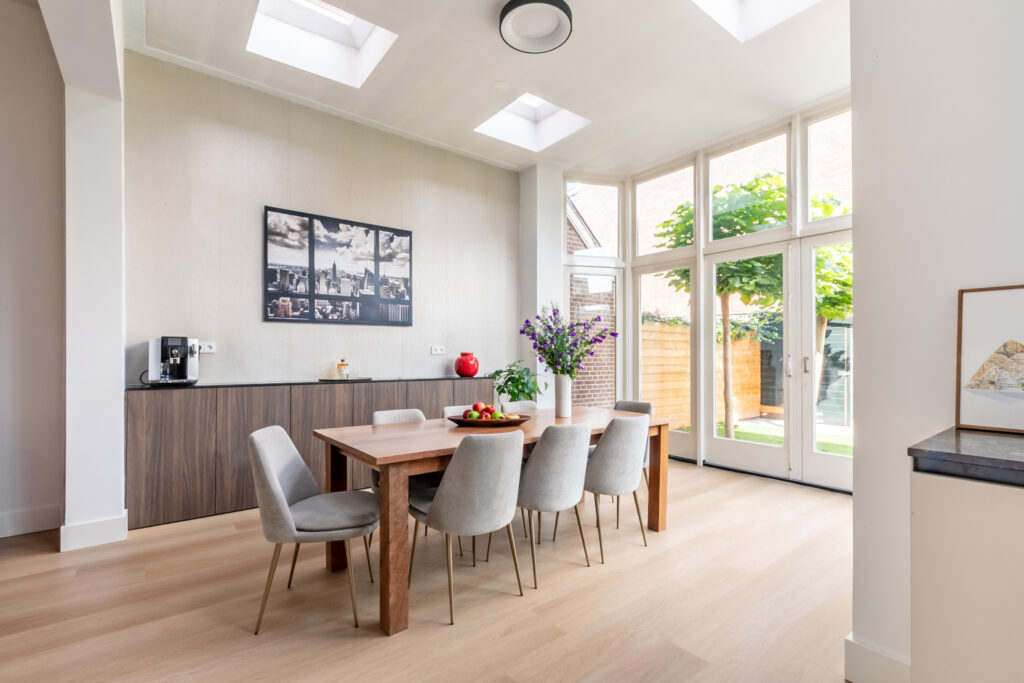 Bright dining room with large windows and wood table.