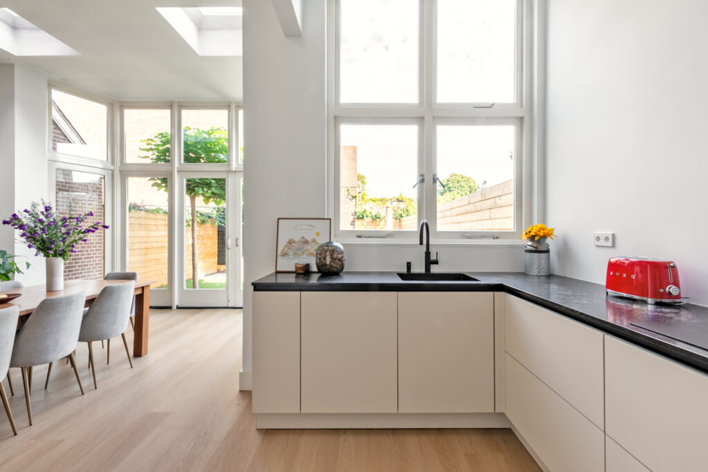 Modern kitchen with large windows and dining area.