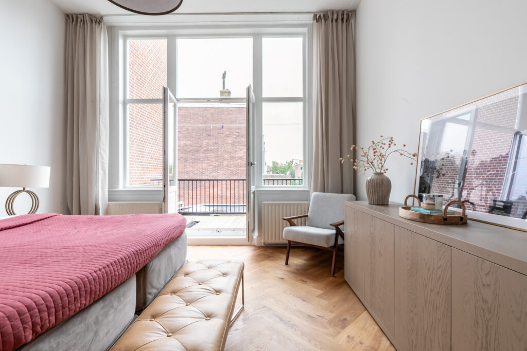 Bright bedroom with balcony, modern decor.