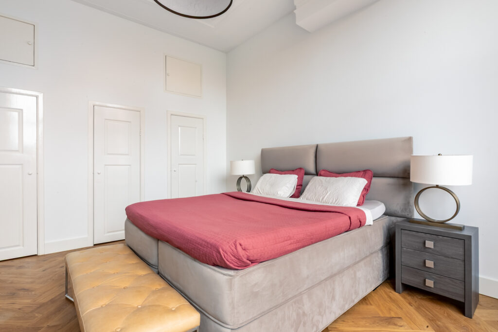 Modern bedroom with red bedding and side tables.