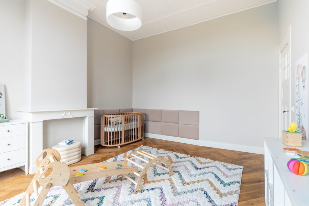 Modern nursery room with crib and play area.