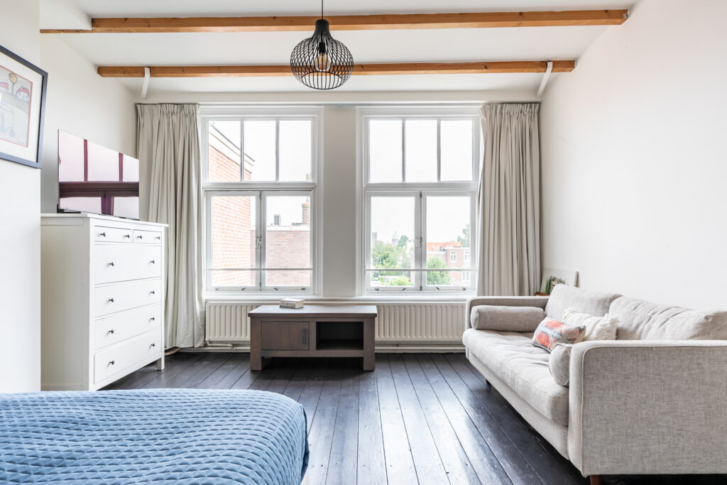 Bright living room with sofa and large windows.