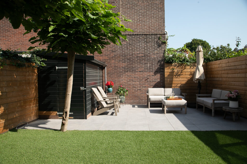 Cozy outdoor patio with seating and greenery.