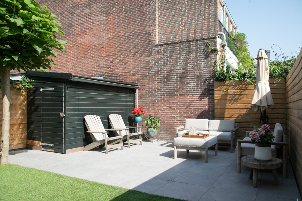 Cozy backyard patio with chairs and sofa.