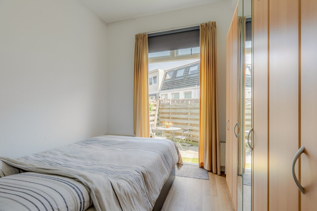 Cozy bedroom with patio view and wardrobe