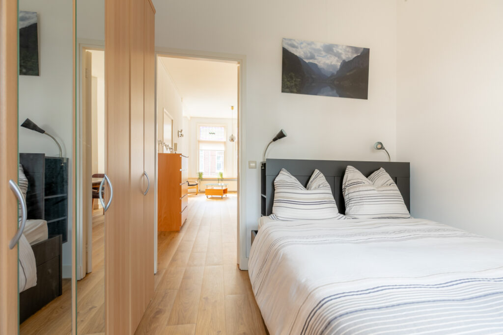 Bright bedroom with striped bedding and open door