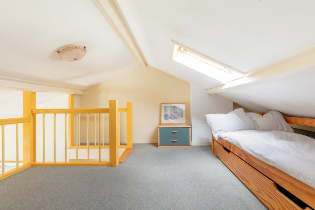 Cozy attic room with skylight and bed