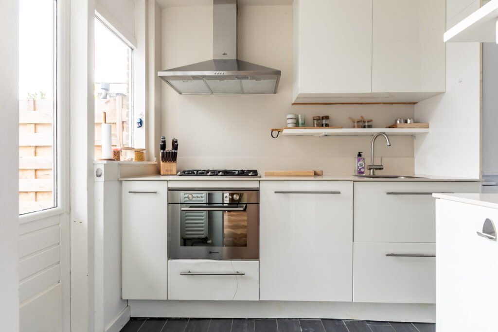 Modern kitchen with white cabinets and stainless steel appliances.