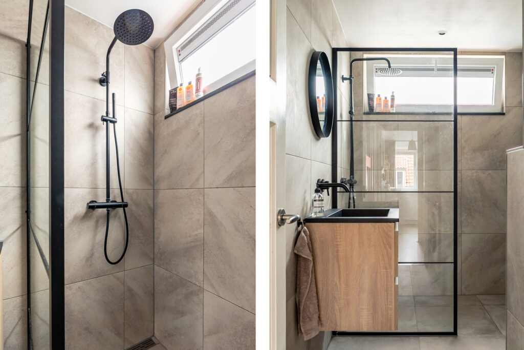 Modern bathroom with black shower and glass partition.