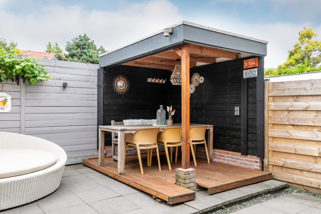 Outdoor patio with wooden dining area and seats.