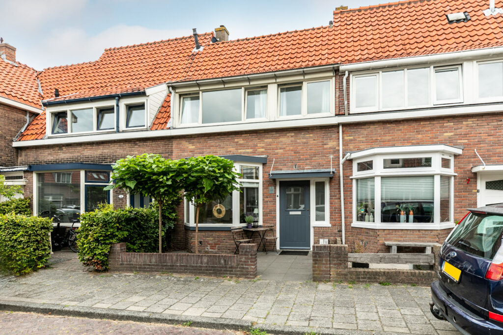 Brick townhouse with orange tile roof and garden.