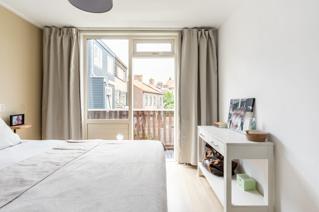Bright bedroom with modern decor and large window view.