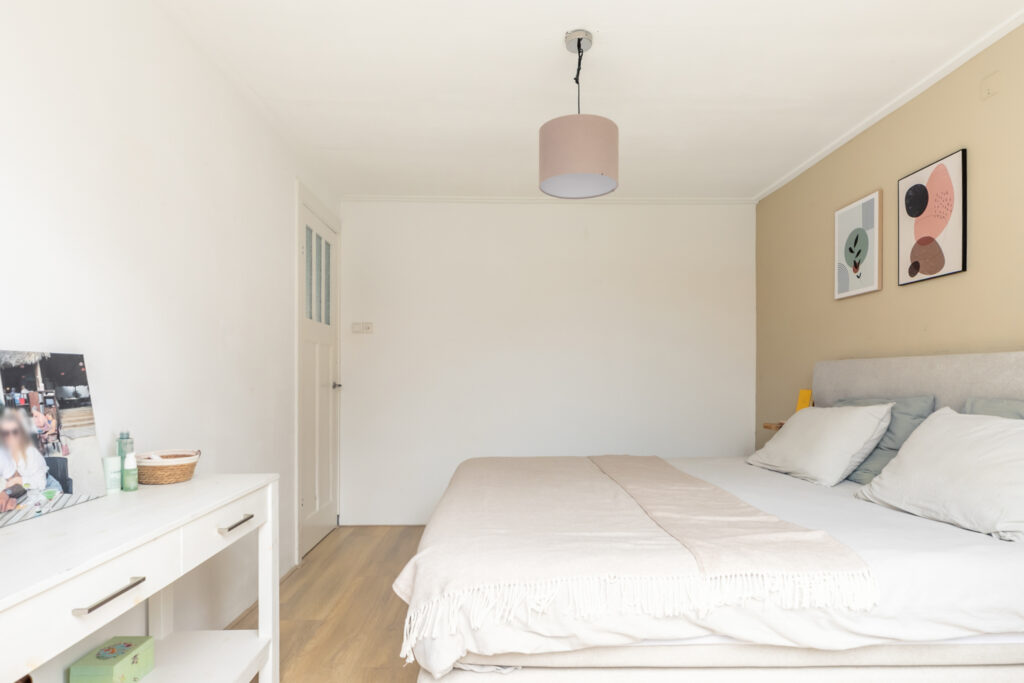 Minimalist bedroom with art and decor.