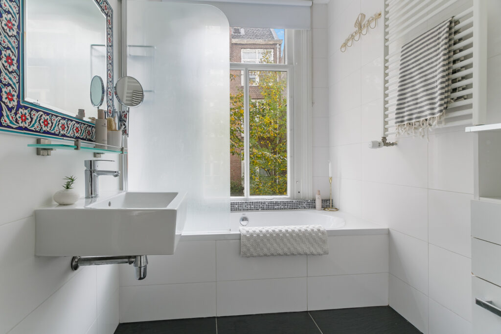 Modern bathroom with sink, mirror, and bathtub.