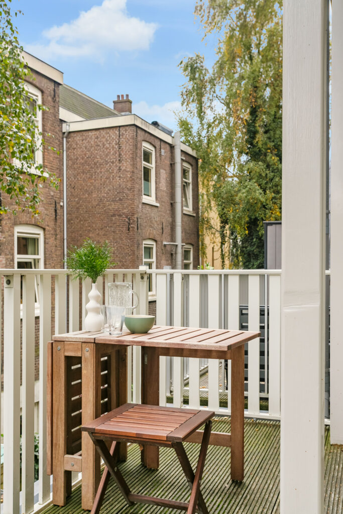 Cozy balcony with table, chair, and plants.