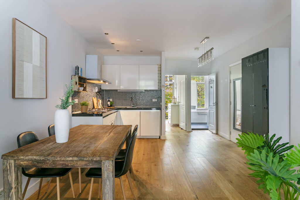 Modern kitchen and dining area with wooden table.