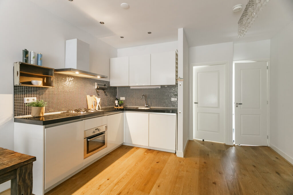 Modern kitchen with wooden floor and white cabinets