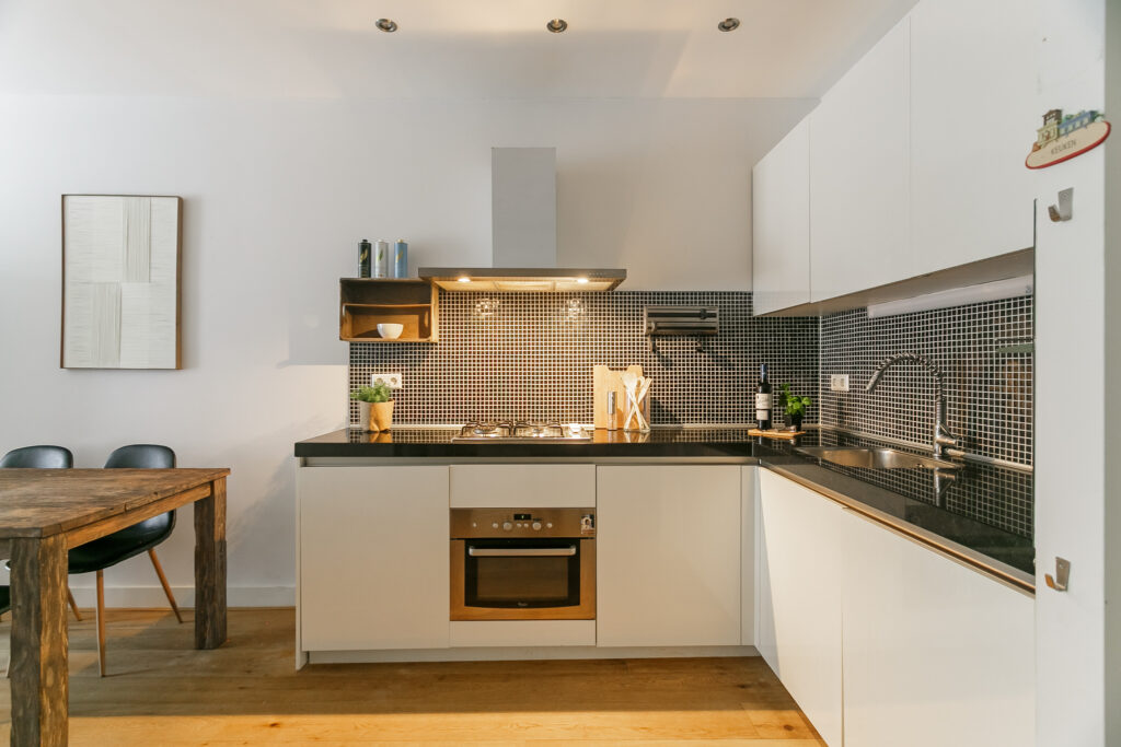 Modern kitchen with wooden table and white cabinets.