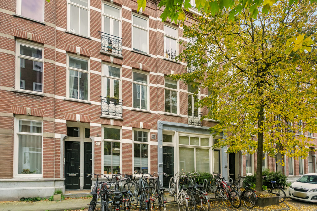 Bicycles parked outside brick apartment building in autumn.