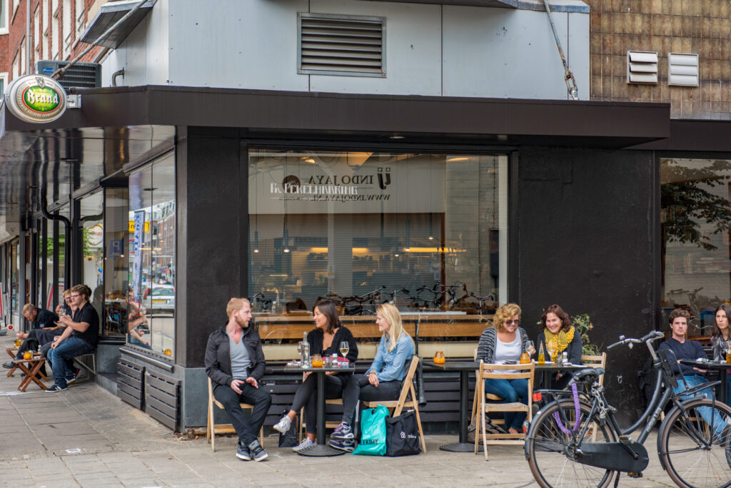 People sitting outside a cafe, enjoying drinks.
