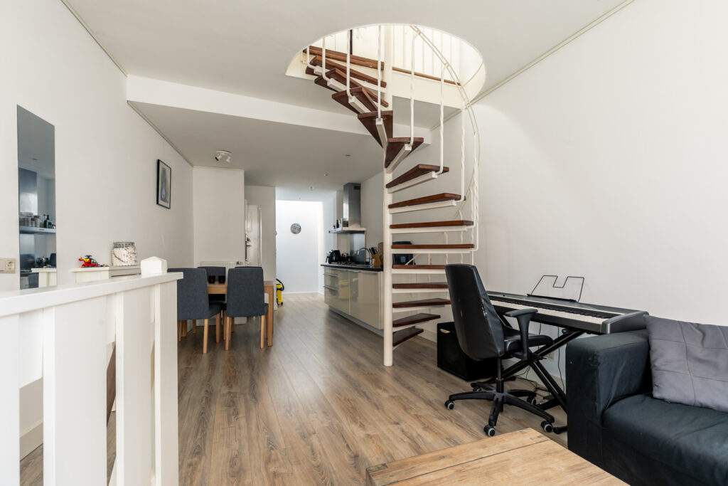 Modern living area with spiral staircase and piano