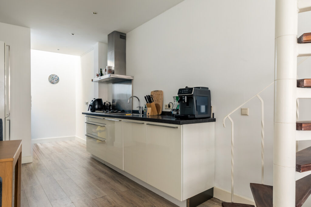 Modern kitchen with appliances and wooden floor.