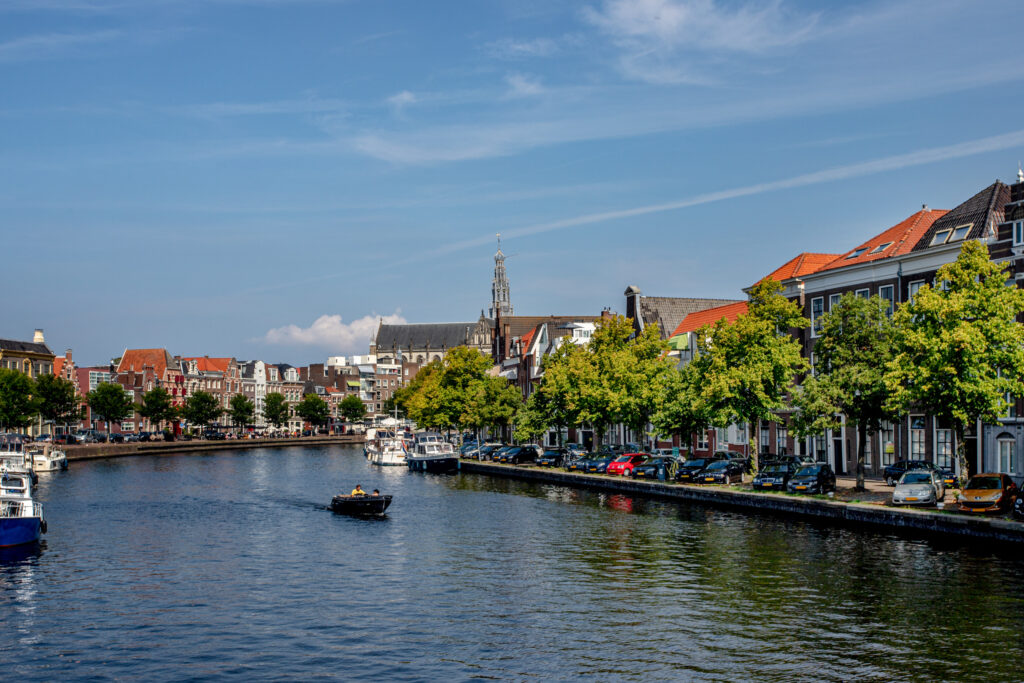 Canal with boats and historic buildings in sunlight.