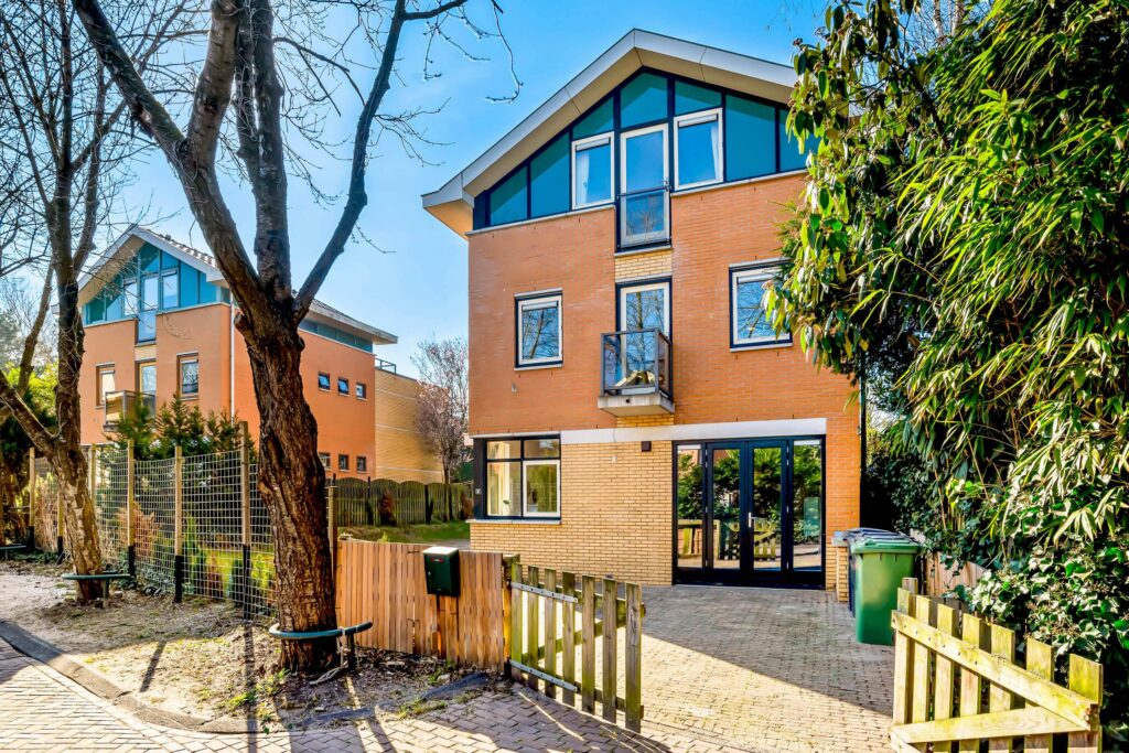 Modern brick house with large windows and garden.