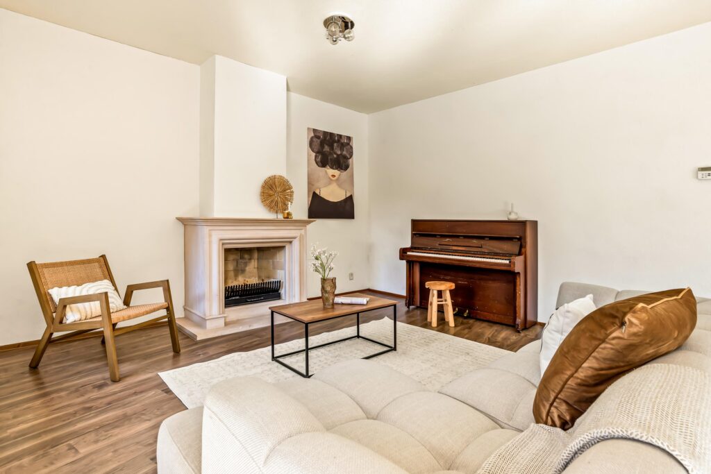 Cozy living room with fireplace and piano.