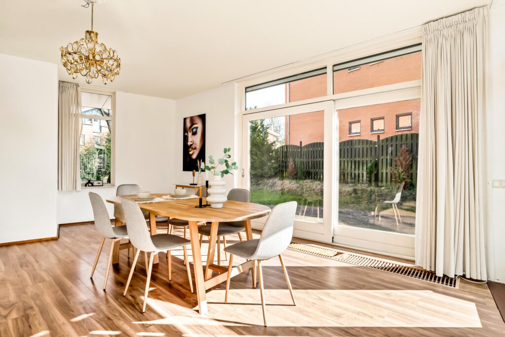 Modern dining room with large windows and table.
