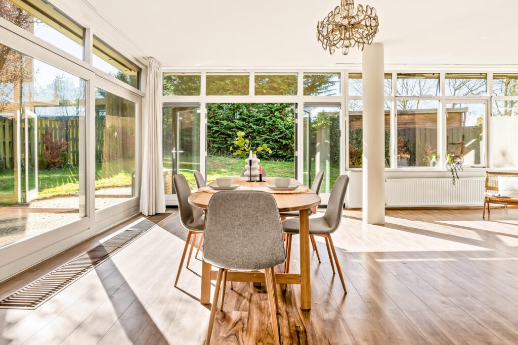 Bright dining room with large windows and table.
