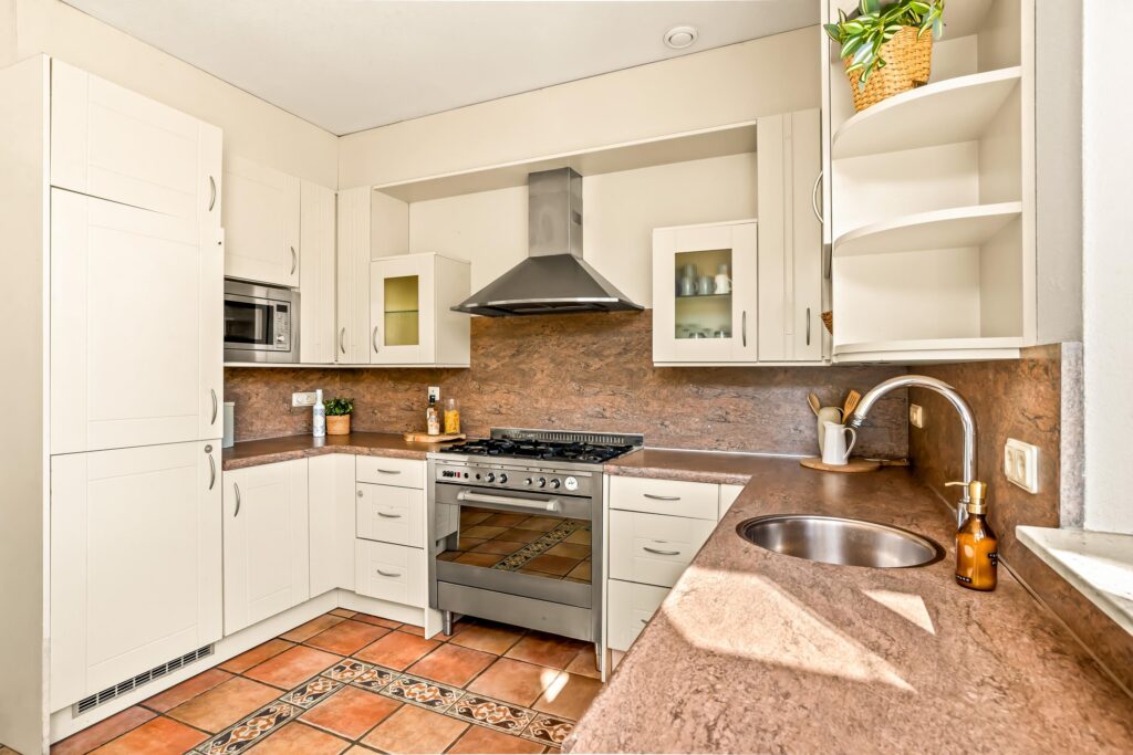 Modern kitchen with white cabinets and stainless steel appliances.